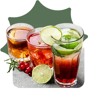 Three iced drinks garnished with lime, mint, and berries
